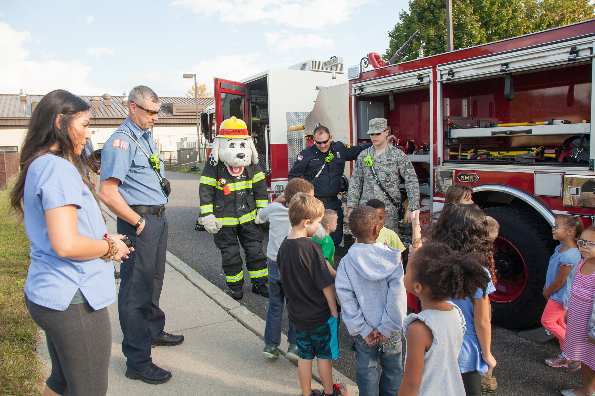 Members of the Joint Base McGuire-Dix-Lakehurst fire department show fire truck gear to children at the Child Development Center, at Joint Base McGuire-Dix-Lakehurst, N.J., Oct. 9, 2015. Members of JB MDL Fire Dept. visited the CDC during Fire Prevention Week. (U.S. Air Force photo by Angela Squicciarini/Released)
