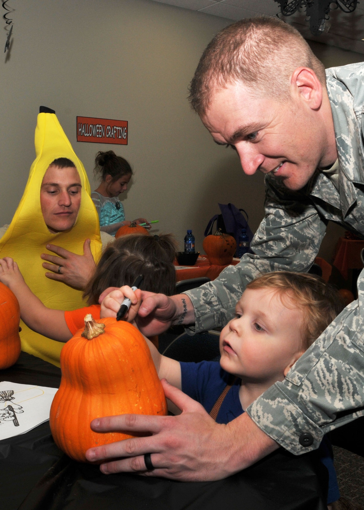 An Airman helps his son draw on a pumpkin during the Montana Air National Guard Airman and Family Readiness Program Halloween party held for children of guardsmen at the 120th Airlift Wing in Great Falls, Mont., Oct. 14, 2015.  (U.S. Air National Guard photo by Senior Master Sgt. Eric Peterson/Released)

