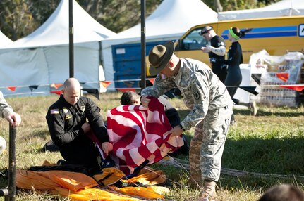 COATESVILLE, Penn. - Sgt. Alex Bahry (left), Golden Knights parachutist, and Sgt. 1st Class Allen Harding, 3rd Battalion/385th Regiment (Basic Combat Training) drill sergeant, fold the American flag after flying it during the Golden Knights' jump during Tough Mudder Philly Oct. 17 in Coatesville, Penn. The U.S. Army Reserve was one of the sponsors for the event. (U.S. Army photo by Sgt. Hector Membreno)