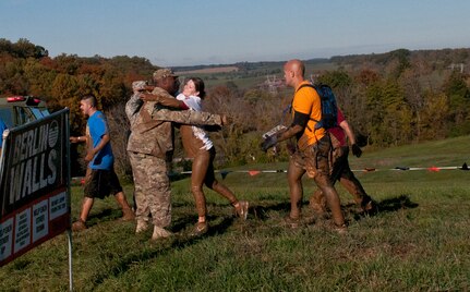 COATESVILLE, Penn. - U.S. Army Reserve Sgt. Raymond Nicholson, firefighter, 369th Engineer Detachment (Firefighting) offers a hug to a Tough Mudder during Tough Mudder Philly in Coatesville, Penn., Oct. 17. The U.S. Army Reserve was one of the sponsors for the event. (U.S. Army photo by Staff Sgt. Debralee Best)