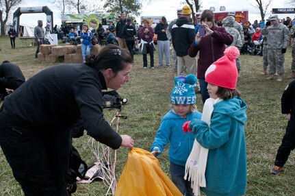 COATESVILLE, Penn. - Sgt. 1st Class Jen Espinoza, Golden Knight parachutist, shows Georgia, 3, and Ashland, 6, how she packs her parachute after jumping during Tough Mudder Philly in Coatesville, Penn., Oct. 17. The U.S. Army Reserve was one of the sponsors for the event. (U.S. Army photo by Staff Sgt. Debralee Best)