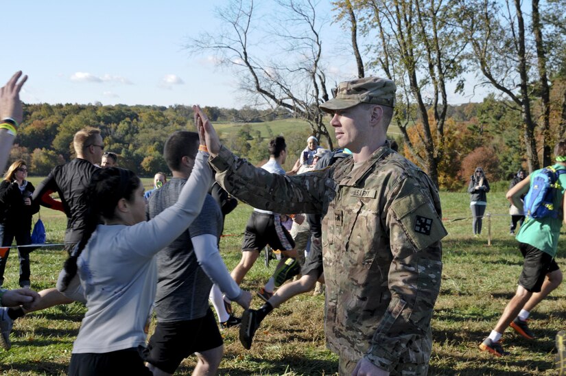 COATESVILLE, Penn. - Sgt. Eric Mills with the 328th Engineer Support Company, high fives a Tough Mudder as she begins the Tough Mudder Philly course Oct. 17 in Coatesville, Penn. The U.S. Army Reserve was one of the sponsors for the event. (U.S. Army photo by Staff Sgt. Bradley Miller)