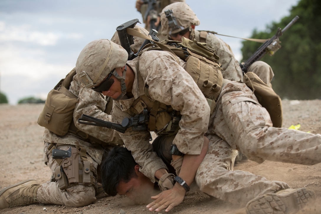 Marines detain a role player during a riot control mission scenario as part of a noncombatant evacuation exercise at Kiwanis Park in Yuma, Ariz., Oct. 16, 2015. The Marines are assigned to the 2nd Battalion, 7th Marine Regiment. U.S. Marine Corps photo by Pvt. George Melendez