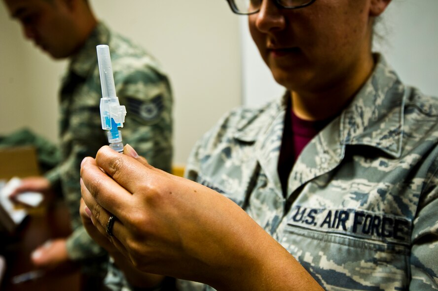 TSgt. Sherlly Lange, 446th Aerospace Medicine Squadron, prepares a flu shot to administer to Airmen from the 446th Airlift Wing on McChord Field, Oct. 17.  The AMDS will be administering flu shots during Unit Training Assemblies October through December this season at multiple sites around the base. (U.S. Air Force Reserve photo by SrA Daniel Liddicoet)