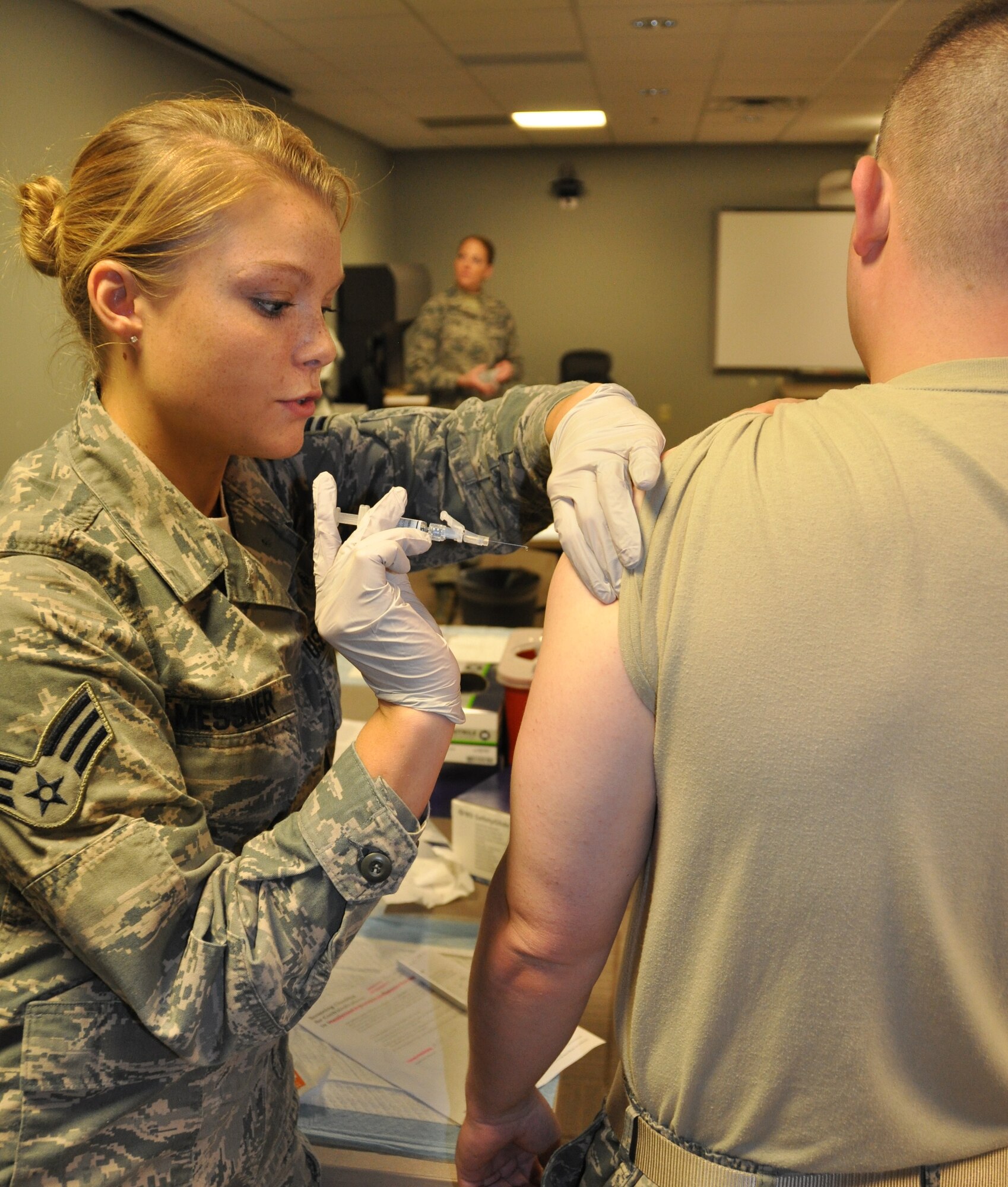 Senior Airman Lindsey Messner (left), 512th Aerospace Medicine Squadron, administers a flu shot to Tech. Sgt. Kenneth Schmid, 512th Force Support Squadron, on Oct. 17, 2015 during the unit training assembly at the base medical clinic at Dover Air Force Base, Del. The wing provided hundreds of immunizations that day in preparation for the upcoming flu season, which most commonly peaks in the United States in January or February.(U.S. Air Force photo/Staff. Sgt. Joe Yanik)