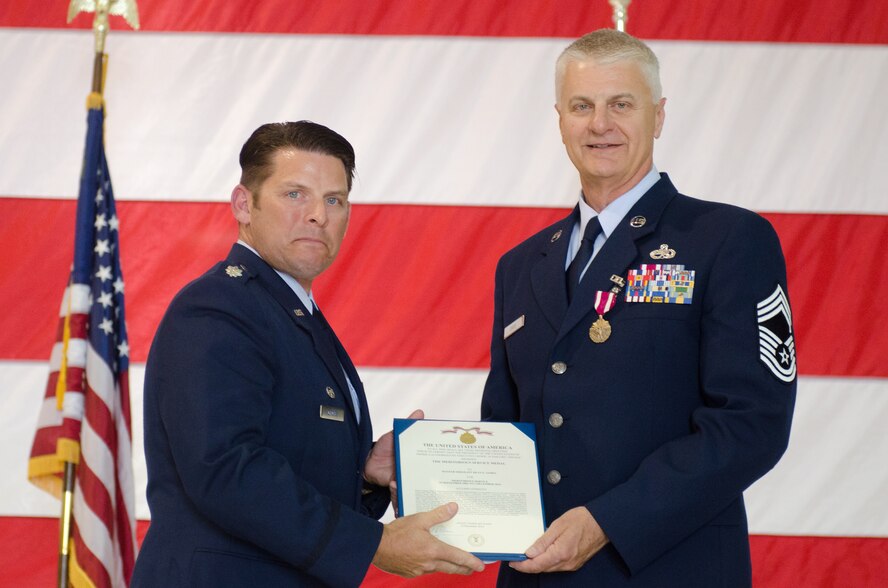 Chief Master Sgt. William K. Davis (right), the outgoing component maintenance flight chief of the 123rd Maintenance Squadron, receives the Meritorious Service Medal from Lt. Col. Ash Groves, commander of the 123rd Maintenance Squadron, during Davis’ retirement ceremony at the Kentucky Air National Guard base in Louisville, Ky., May 16, 2015.  Davis ends his career with more than three decades in the Kentucky Air National Guard. (U.S. Air National Guard photo by Senior Airman Joshua Horton)