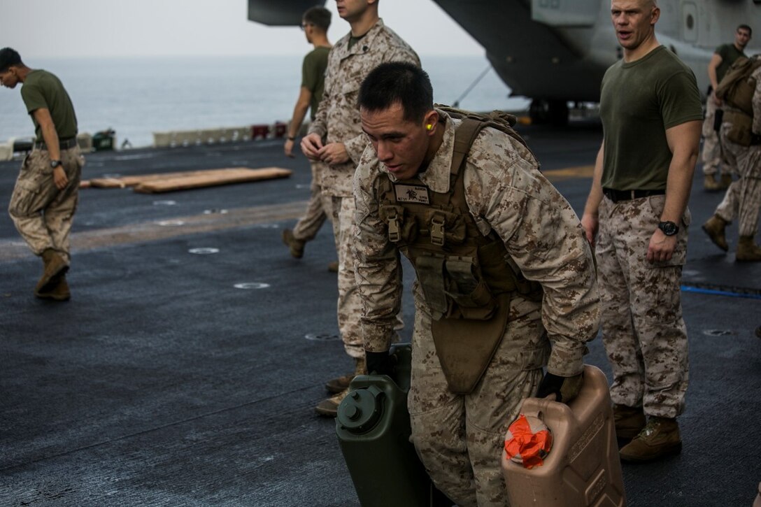 ARABIAN GULF (Oct. 16, 2015) A U.S. Marine with Lima Company, Battalion Landing Team 3rd Battalion, 1st Marine Regiment, 15th Marine Expeditionary Unit, takes off running with water jugs during a deck shoot aboard the amphibious assault ship USS Essex (LHD 2). The Marines ran and grappled between courses of fire to practice shooting with an increased heart rate. The 15th MEU, embarked aboard the ships of the Essex Amphibious Ready Group, is deployed to maintain regional security in the U.S. 5th Fleet area of operations. (U.S. Marine Corps photo by Cpl. Anna Albrecht/Released)