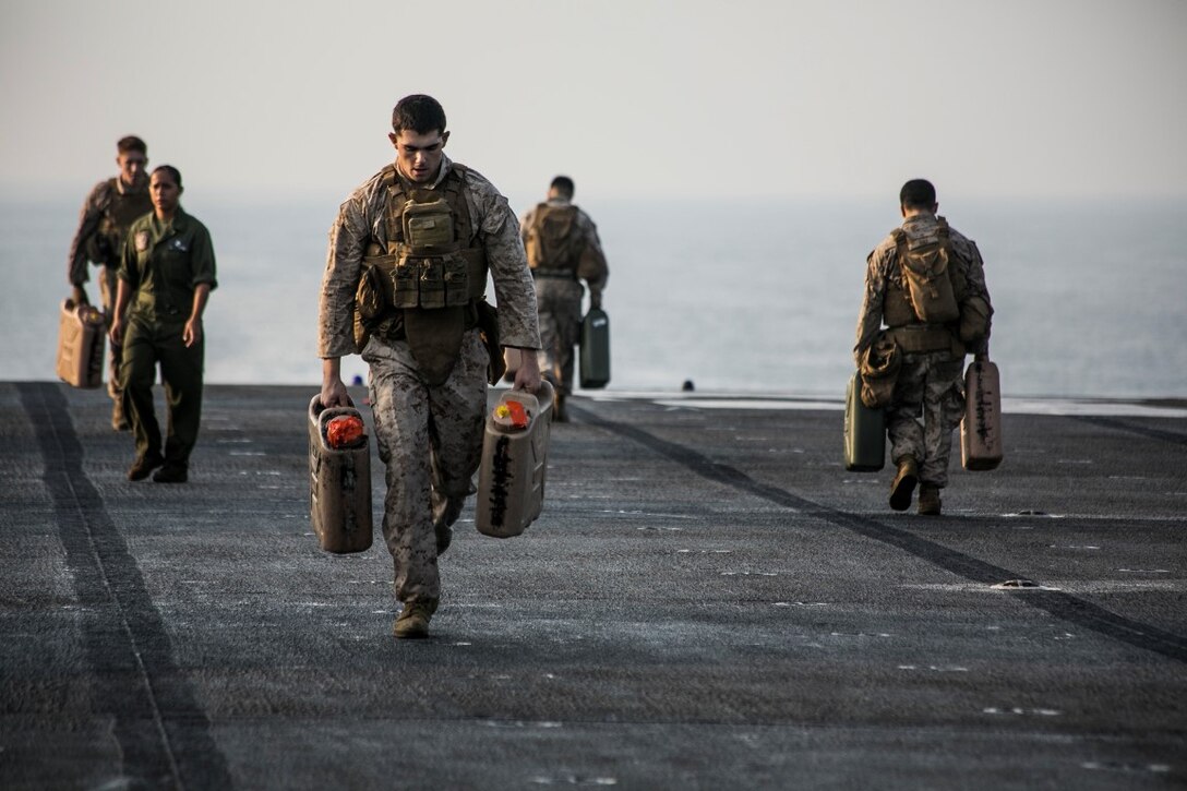 ARABIAN GULF (Oct. 16, 2015) U.S. Marines with Lima Company, Battalion Landing Team 3rd Battalion, 1st Marine Regiment, 15th Marine Expeditionary Unit, run with water jugs during a deck shoot aboard the amphibious assault ship USS Essex (LHD 2). The Marines grappled and ran between courses of fire to practice shooting with an increased heart rate. The 15th MEU, embarked aboard the ships of the Essex Amphibious Ready Group, is deployed to maintain regional security in the U.S. 5th Fleet area of operations. (U.S. Marine Corps photo by Cpl. Anna Albrecht/Released)