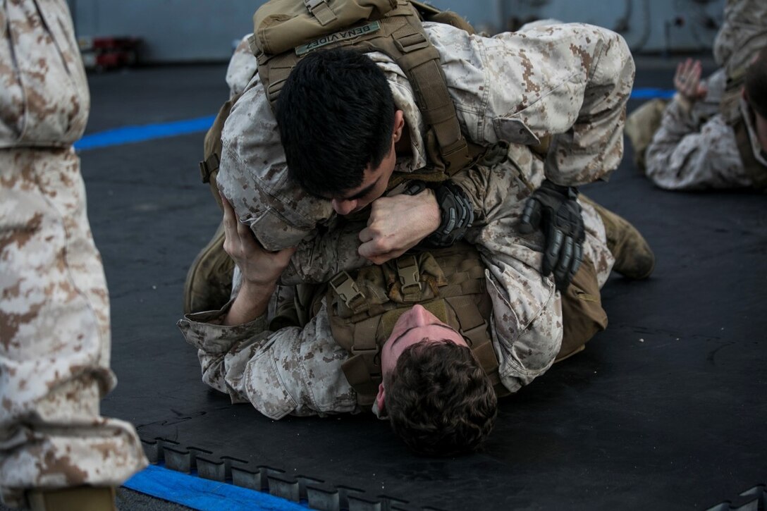 ARABIAN GULF (Oct. 16, 2015) U.S. Marines with Lima Company, Battalion Landing Team 3rd Battalion, 1st Marine Regiment, 15th Marine Expeditionary Unit, grapple during a deck shoot aboard the amphibious assault ship USS Essex (LHD 2). The Marines grappled and ran between courses of fire to practice shooting with an increased heart rate.  The 15th MEU, embarked aboard the ships of the Essex Amphibious Ready Group, is deployed to maintain regional security in the U.S. 5th Fleet area of operations. (U.S. Marine Corps photo by Cpl. Anna Albrecht/Released)