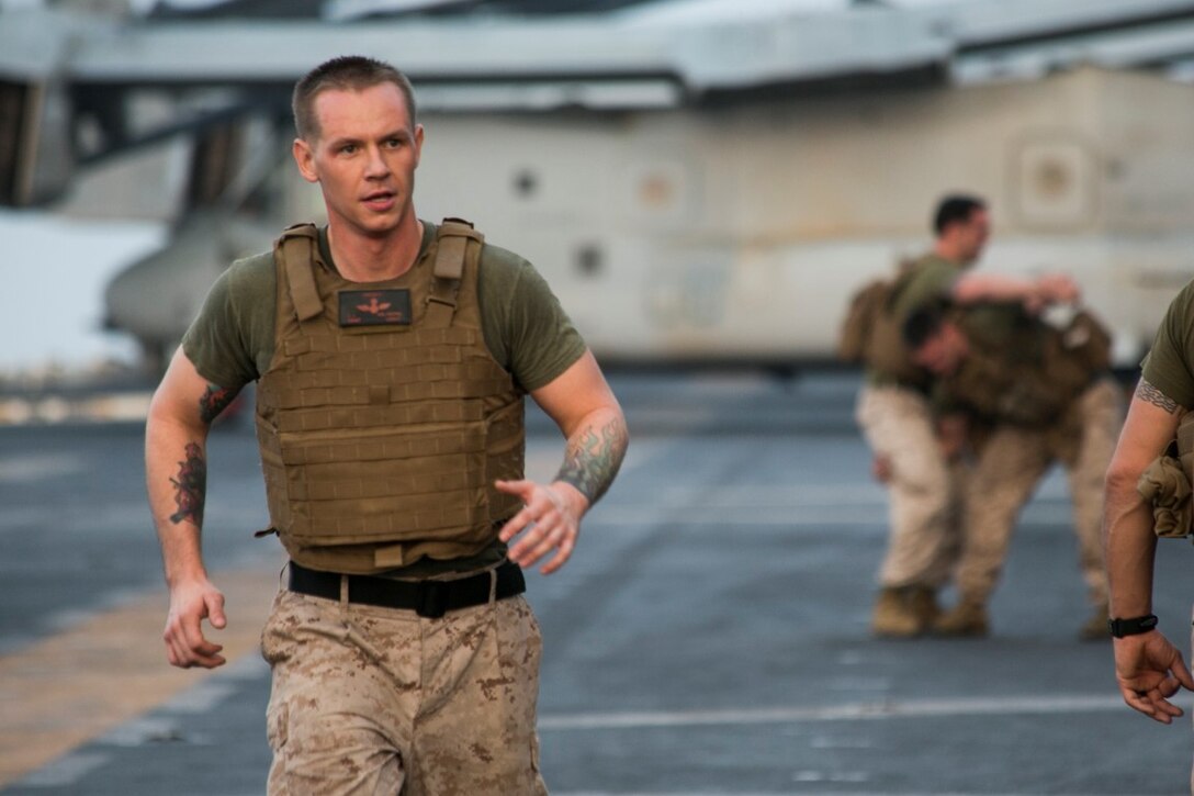 ARABIAN GULF (Oct. 17, 2015) U.S. Marine Staff Sgt. Joshua Milhorn assists during a corporals course physical training event aboard the amphibious assault ship USS Essex (LHD 2). Milhorn is an aviation ordnance system technician with Marine Aviation Logistics Squadron 13, Marine Medium Tiltrotor Squadron 161 (Reinforced), 15th Marine Expeditionary Unit. Milhorn has instructed every corporals course hosted on ship because he likes having an influence on the future leaders of the Marine Corps. The 15th MEU, embarked aboard the ships of the Essex Amphibious Ready Group, is deployed to maintain regional security in the U.S. 5th Fleet area of operations. (U.S. Marine Corps photo by Cpl. Anna Albrecht/ Released)