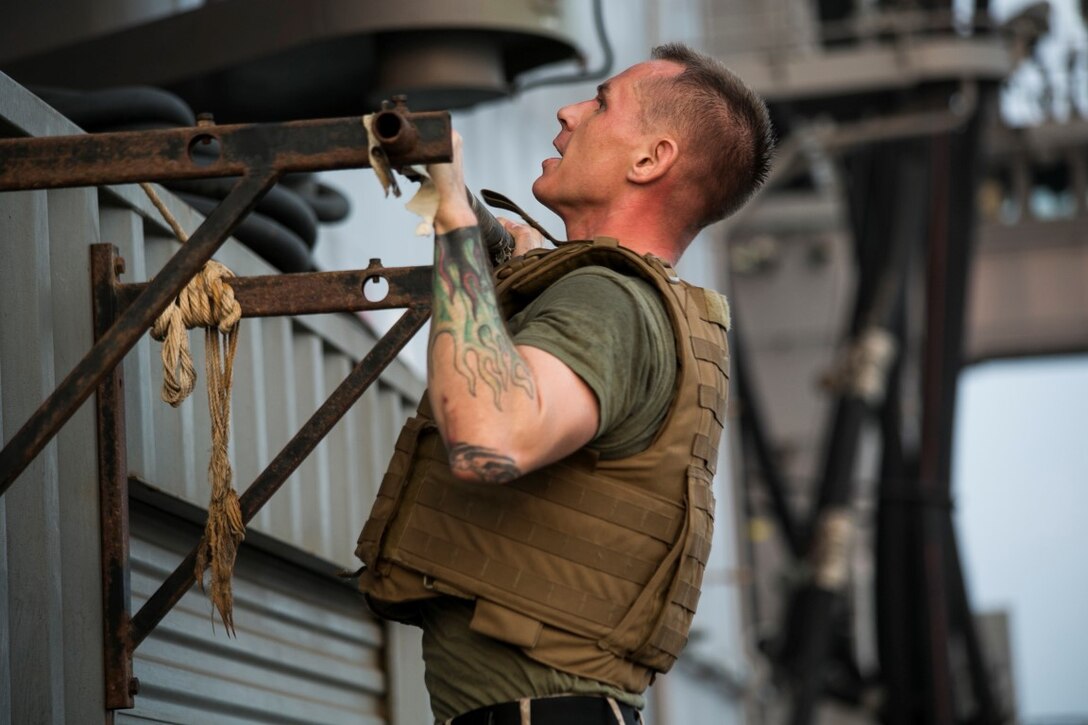 ARABIAN GULF (Oct. 17, 2015) U.S. Marine Staff Sgt. Joshua Milhorn does pull-ups during a corporals course physical training event aboard the amphibious assault ship USS Essex (LHD 2). Milhorn is an aviation ordnance system technician with Marine Aviation Logistics Squadron 13, Marine Medium Tiltrotor Squadron 161 (Reinforced), 15th Marine Expeditionary Unit. Milhorn has instructed every corporals course hosted on ship because he likes having an influence on the future leaders of the Marine Corps. The 15th MEU, embarked aboard the ships of the Essex Amphibious Ready Group, is deployed to maintain regional security in the U.S. 5th Fleet area of operations. (U.S. Marine Corps photo by Cpl. Anna Albrecht/ Released)