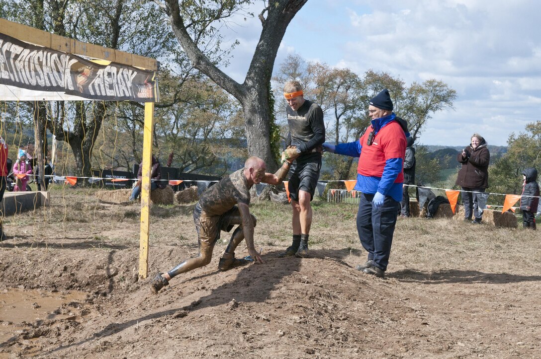 COATESVILLE, Penn. - A Tough Mudder helps another up after completing the final obstacle of the Tough Mudder Philly course, the Electroshock, in Coatesville, Penn., Oct. 18. The U.S. Army Reserve was one of the sponsors for the event.(U.S. Army photo by Staff Sgt. Debralee Best)