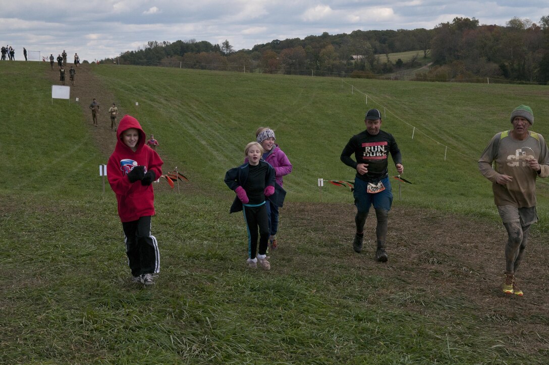 COATESVILLE, Penn. - Children run with two Tough Mudders during the final stretch of the Tough Mudder Philly course in Coatesville, Penn., Oct. 18. The U.S. Army Reserve was one of the sponsors for the event.(U.S. Army photo by Staff Sgt. Debralee Best)