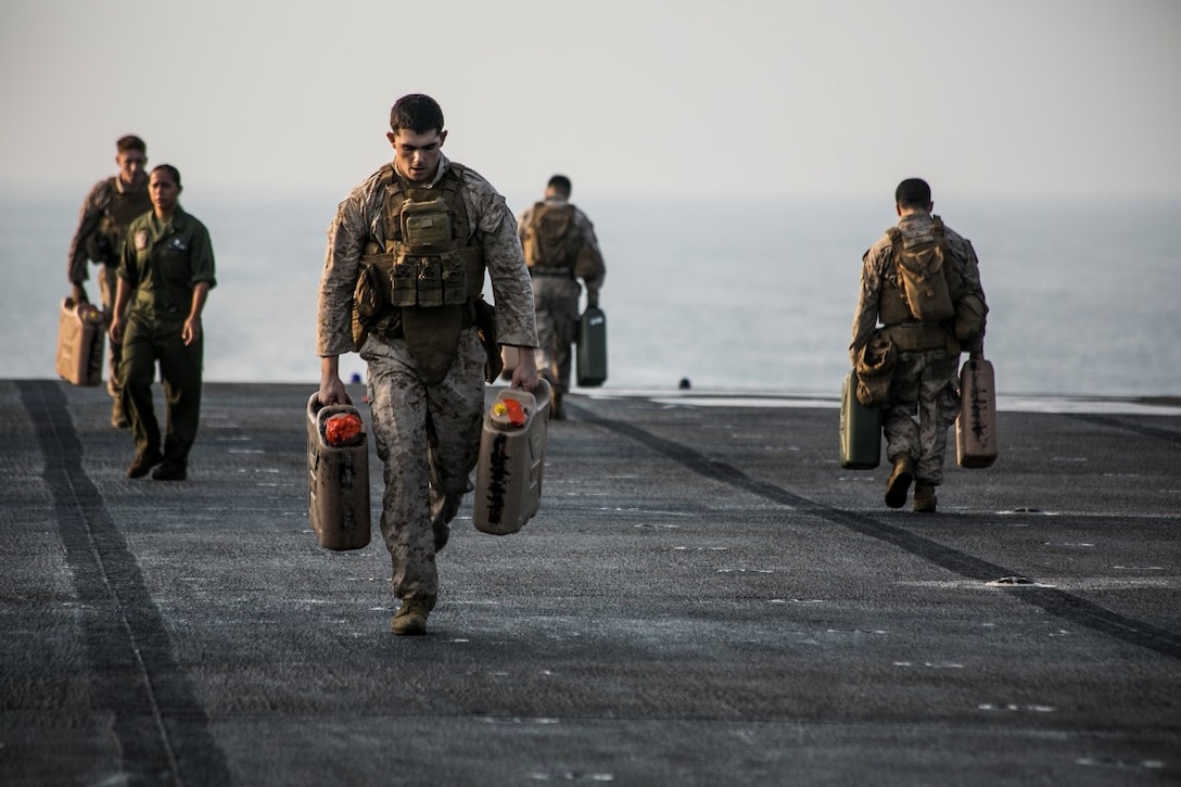 U.S. Marines with Lima Company, Battalion Landing Team 3rd Battalion, 1st Marine Regiment, 15th Marine Expeditionary Unit, run with water jugs during a deck shoot aboard the amphibious assault ship USS Essex (LHD 2). The Marines grappled and ran between courses of fire to practice shooting with an increased heart rate. The 15th MEU, embarked aboard the ships of the Essex Amphibious Ready Group, is deployed to maintain regional security in the U.S. 5th Fleet area of operations. 