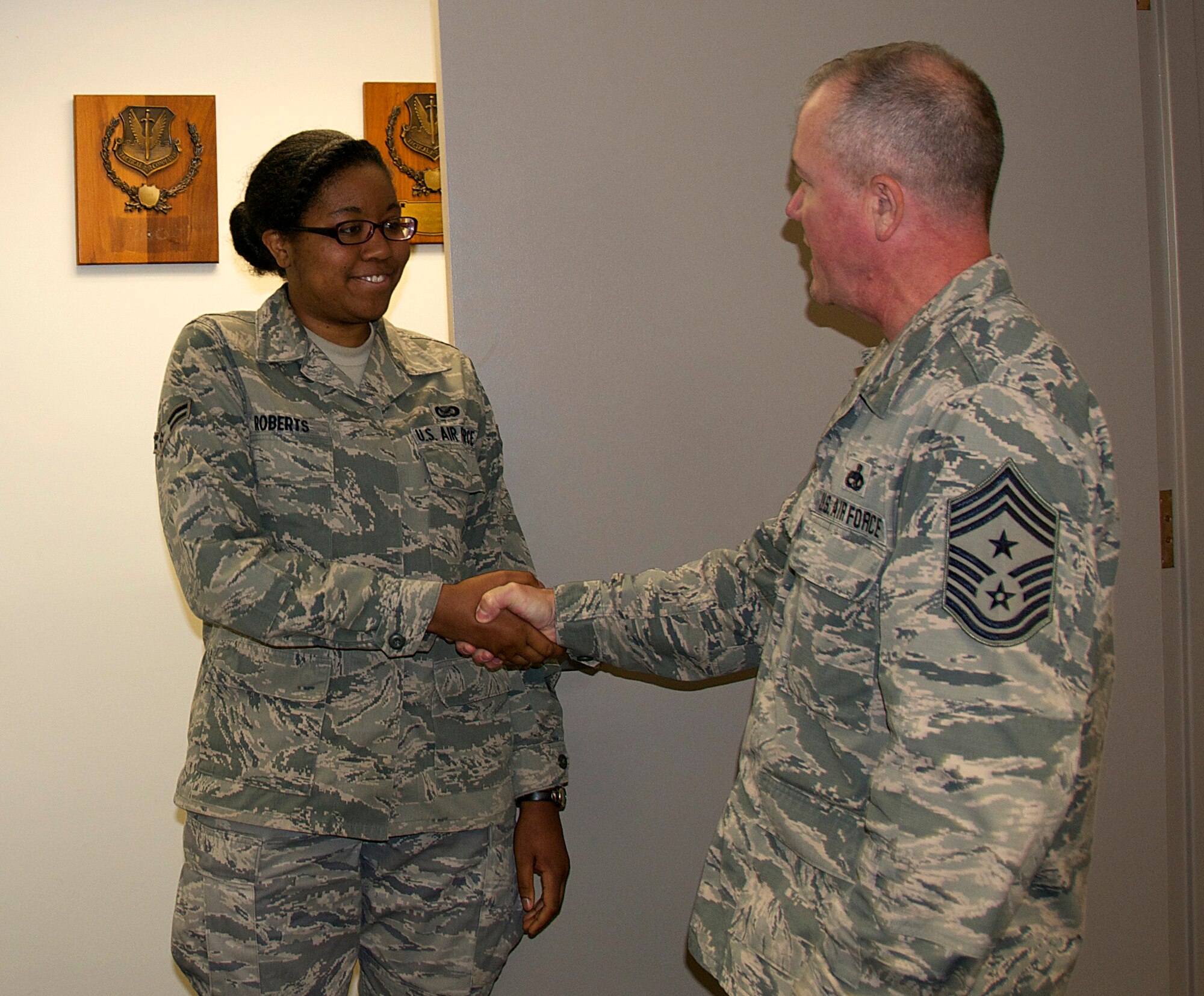 Senior Airman Johnisa B. Roberts, 192nd Fighter Wing Public Affairs photojournalist, received an outstanding performance chip from Command Chief Master Sgt. Michael J. Bouley, 192nd FW command chief, September 13, 2015 at Joint Base Langley-Eustis, Virginia. Chief Bouley coined (“chipped”) Roberts to recognize her for obtaining her Bachelor’s degree in Mathematics, May 2015 from Christopher Newport University in Newport News, Virginia. Roberts is currently continuing her education at CNU as part of a five-year program to obtain her Master’s in the Arts of Teaching. (U.S. Air National Guard photo by Master Sgt. Carlos J. Claudio/Released)