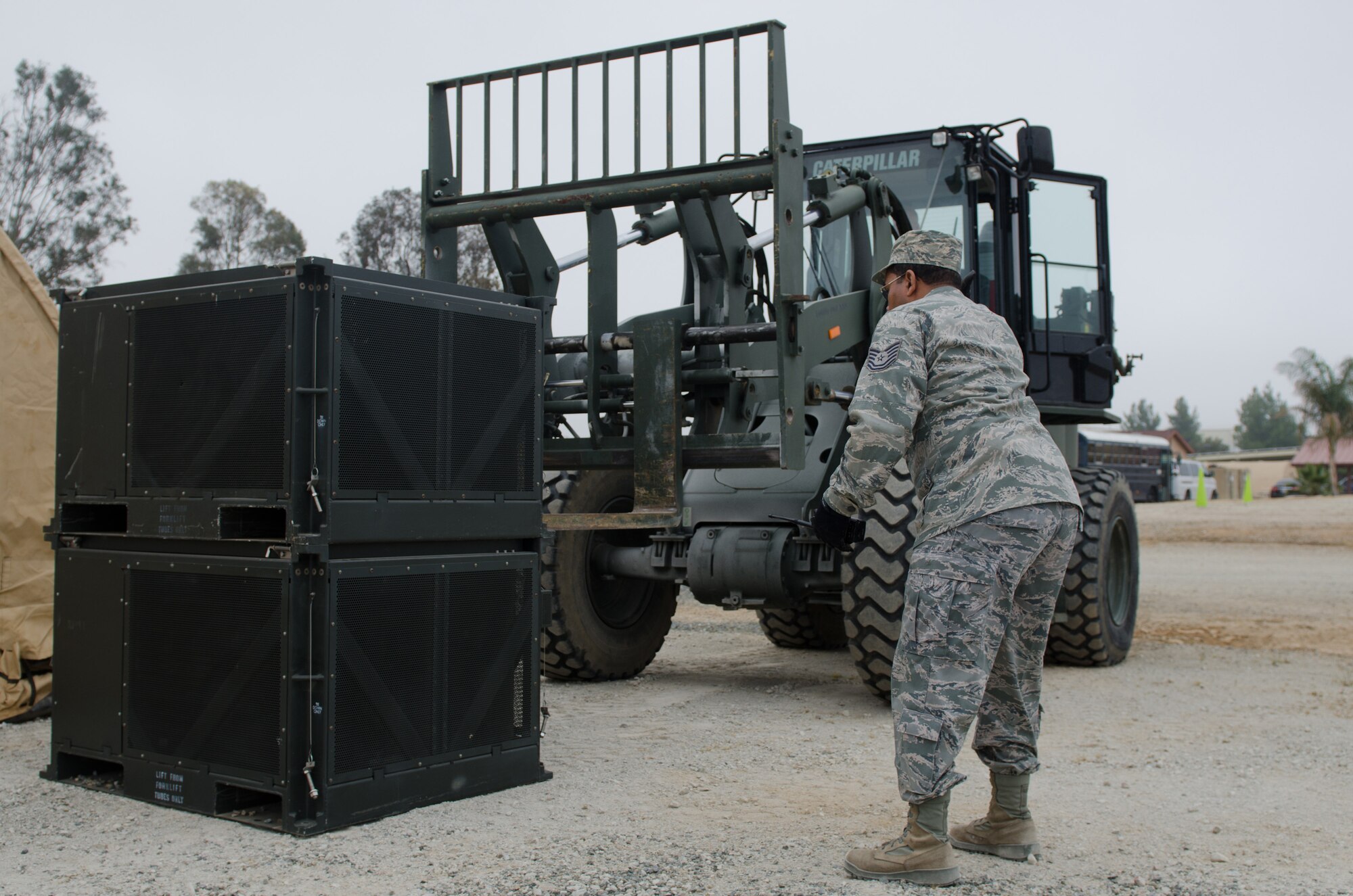 Tech Sgt. Darry Brown, a Heating, Ventilation and Air Conditioning technicians from the Kentucky Air National Guard’s 123rd Civil Engineer Squadron, directs a forklift to transport HVAC equipment during a training scenario at March Air Reserve Base, Calif., on June 11, 2015. The exercise was designed to simulate a real-world mission. (U.S. Air National Guard photo by Senior Airman Joshua Horton)
