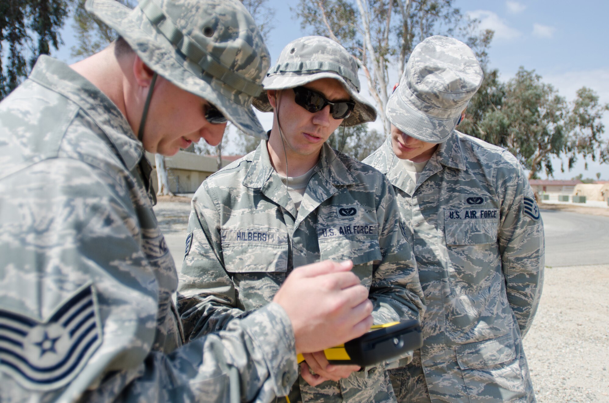 Tech Sgt. Nick Ketterer (left), Staff Sgt. Abe Hilbers (center) and Staff Sgt. Daniel Brooks (right), all Airmen from the Kentucky Air National Guard’s 123rd Civil Engineer Squadron, use surveying equipment during a training scenario at March Air Reserve Base, Calif., on June 10, 2015. The exercise was designed to simulate a real-world mission. (U.S. Air National Guard photo by Senior Airman Joshua Horton)