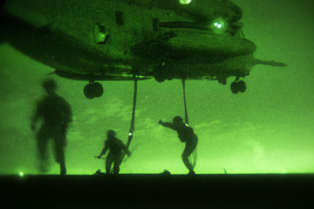 As seen through a night-vision device, a Marine Corps CH-53E Super Stallion helicopter prepares to lift a 6,200 pound steel girder during external lift training at Marine Corps Air Station Miramar, Calif., Oct. 14, 2015. U.S. Marine Corps photo by Sgt. Brian Marion