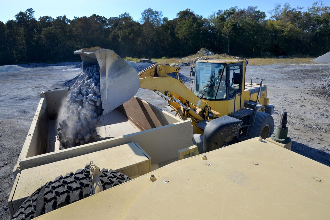 North Carolina Army National Guardsmen work to repair multiple sections of Indian Hut Road in Andrews, South Carolina, Oct. 16, 2015. The guardsmen are engineers assigned to the 878th Engineer Company, and logistical support members are assigned to the Forward Support Company, 505th Engineer Battalion. The engineers are restoring the road for fire, police, emergency management and general transportation needs of the businesses and homes along the more than eight miles threatened by the recent historic floods. North Carolina Army National Guard photo by Sgt. 1st Class Robert Jordan