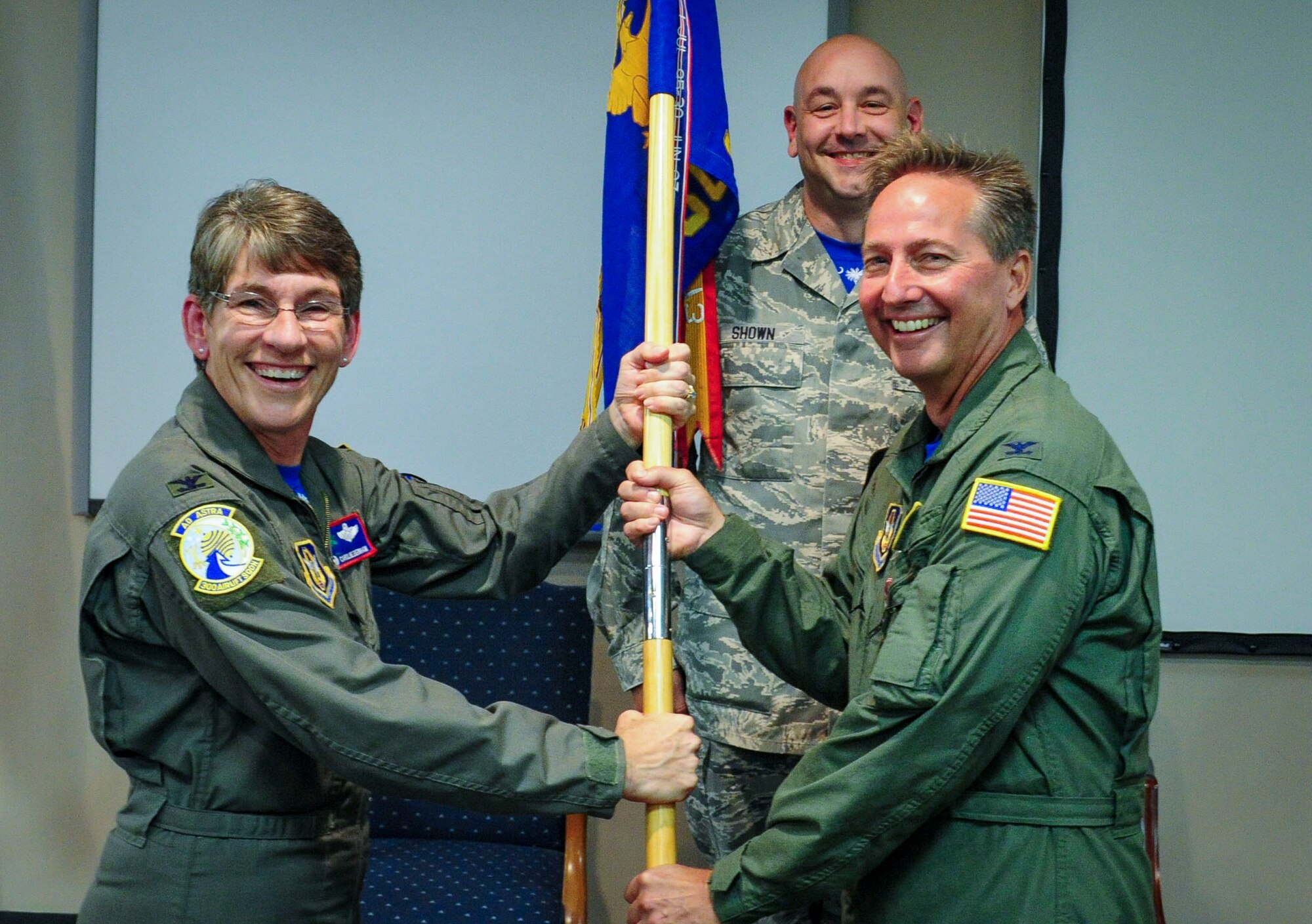 Col. Eric Fornell passes the 300th Airlift Squadron guidon and relinquishes  command to Col. Caroline Evernham, 315th Operations Group commander during the 300 AS Change of Command ceremony at Joint Base Charleston, S.C. October 17, 2015. 