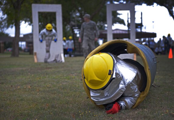 A U.S. Air Force Airman with the 27th Special Operations Civil Engineer Squadron low crawls through a tube as part of an obstacle course during the 16th Annual Squadron Fire Muster Oct. 16, 2015, at Cannon Air Force Base, N.M. Six teams from various squadrons across the 27th Special Operations Wing came together to compete in this year’s muster. (U.S. Air Force photo/Staff Sgt. Alexx Pons)