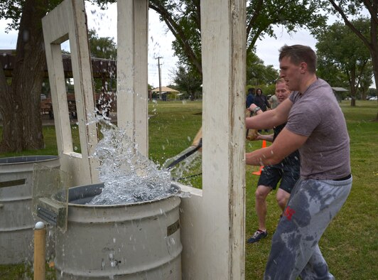 A U.S. Air Force Airmen with the 27th Special Operations Security Forces Squadron fill a barrel up with water as part of the bucket brigade challenge during the 16th Annual Squadron Fire Muster Oct. 16, 2015, at Cannon Air Force Base, N.M. Six teams from various squadrons across the 27th Special Operations Wing came together to compete in this year’s muster. (U.S. Air Force photo/Staff Sgt. Alexx Pons)