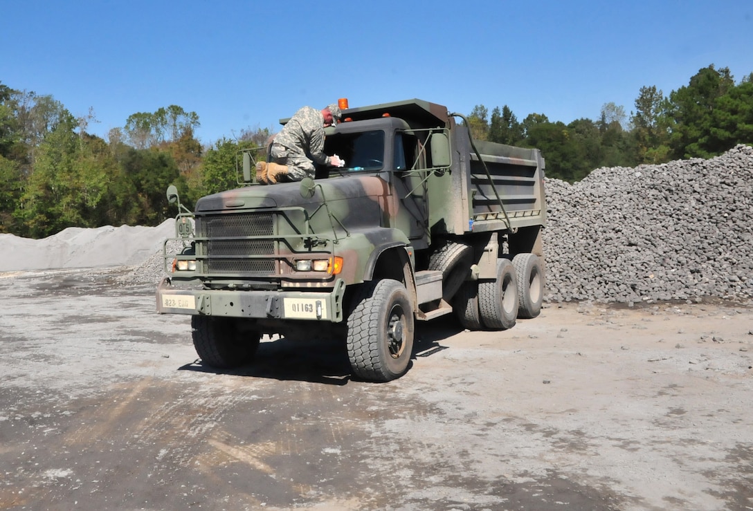 A North Carolina National Guardsman washes the window on a 10-ton dump truck before continuing to repair multiple sections of Indian Hut Road in Andrews, South Carolina, Oct. 16, 2015. North Carolina Army National Guard photo