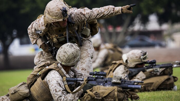 A squad leader with 2nd Battalion, 7th Marine Regiment, based out of Marine Corps Air Ground Combat Center Twentynine Palms, Calif., directs his Marines to their objective point during the Weapons and Tactics Instructor course 1-16 non-combatant evacuation exercise at Kiwanis Park in Yuma, Ariz., Friday, Oct. 16, 2015. The Marines reinforced initial ground units preparing for the evacuation. 
