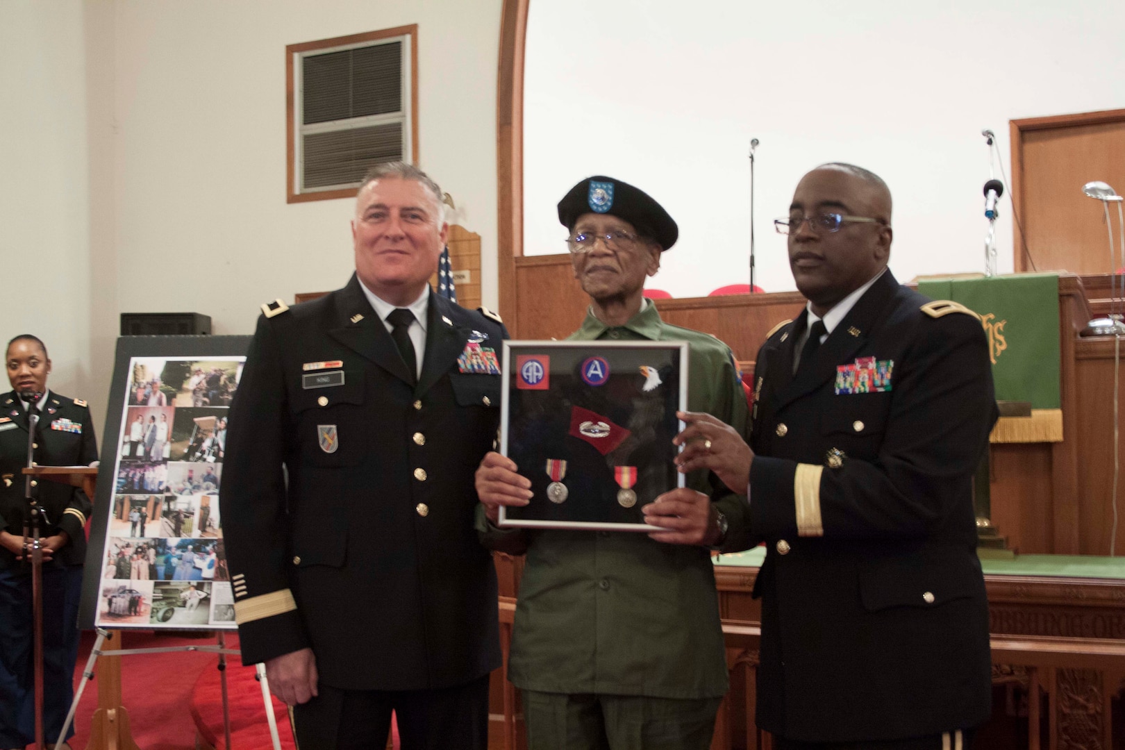 DLA Distribution commander Army Brig. Gen. Richard Dix, on right, and Deputy Commanding General, National Guard Army Brig. Gen. John King, left, present veteran Army Sgt. Earnest Felton Jett, Sr., with medals and badges for his service in World War II.