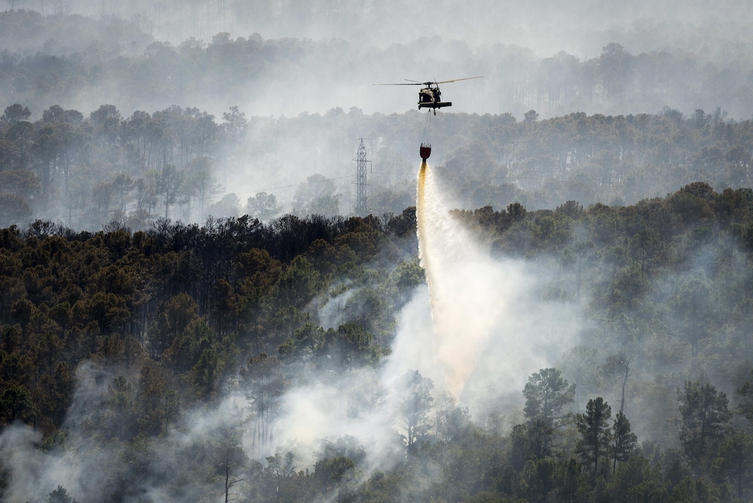 A Texas Army National Guard UH-60 Black Hawk helicopter helps fight wildfires threatening homes and property near Bastrop, Texas, Oct. 14, 2015. Texas Army National Guard photo by Sgt. 1st Class Malcolm McClendon