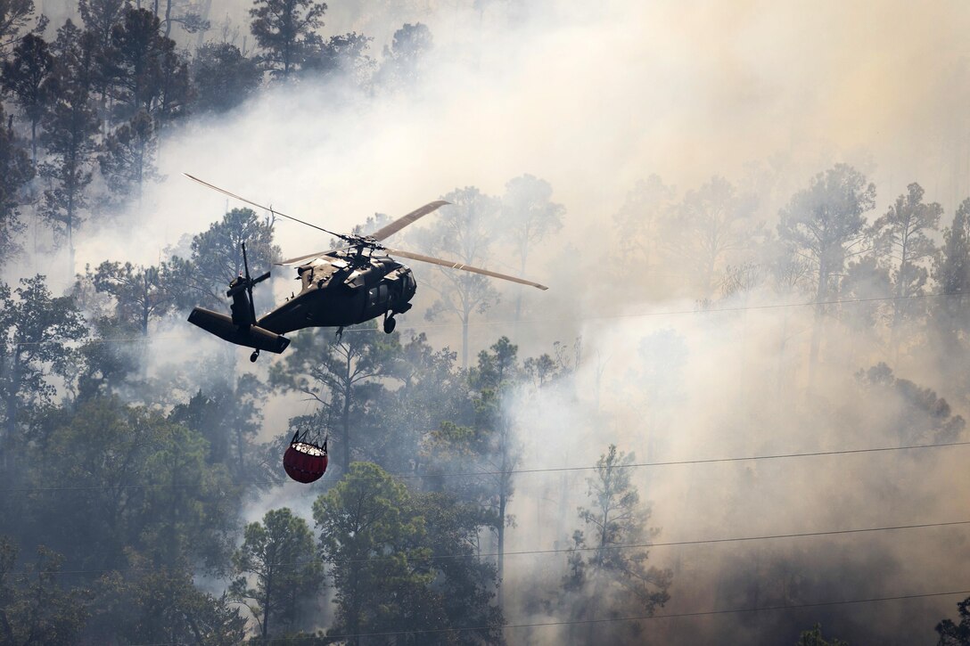 A Texas Army National Guard UH-60 Black Hawk helicopter helps fight wildfires threatening homes and property near Bastrop, Texas, Oct. 14, 2015. Texas Army National Guard photo by Sgt. 1st Class Malcolm McClendon