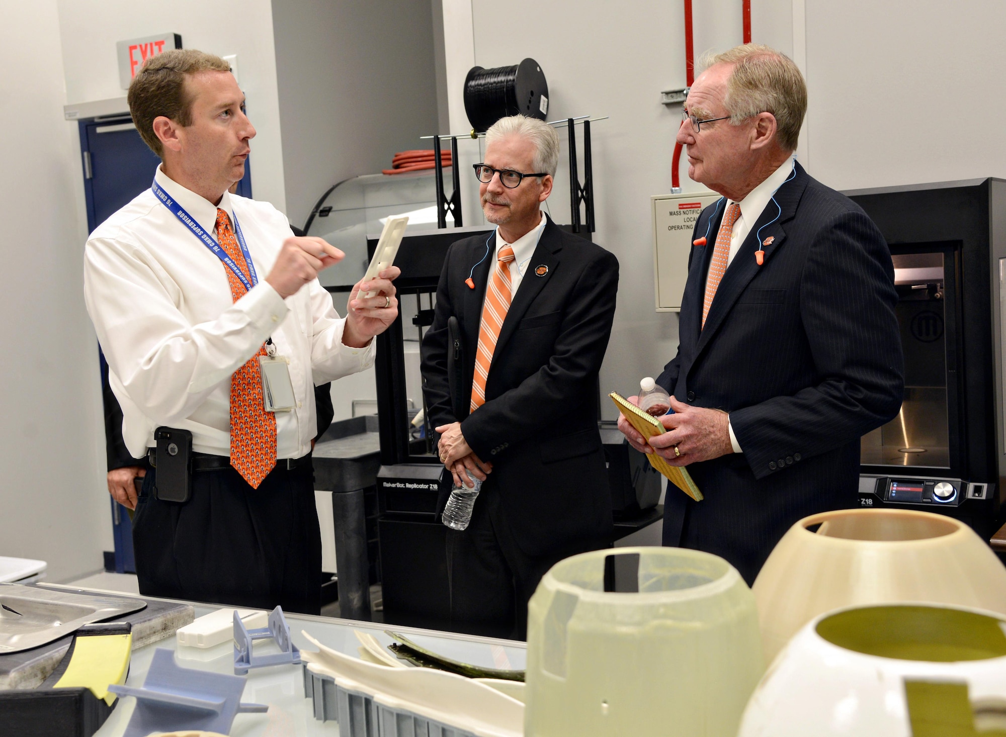 Martin Williams, the 76th Commodities Maintenance Group engineering branch chief, shows parts made using 3-D printing technology in the reverse engineering and critical tooling cell to Dr. Charles Bunting, associate dean of Research and Sponsored Programs at Oklahoma State University, and Dr. Burns Hargis, OSU president, during a tour of OC-ALC engineering and software facilities Oct. 7, 2015. (Air Force photo/Kelly White)