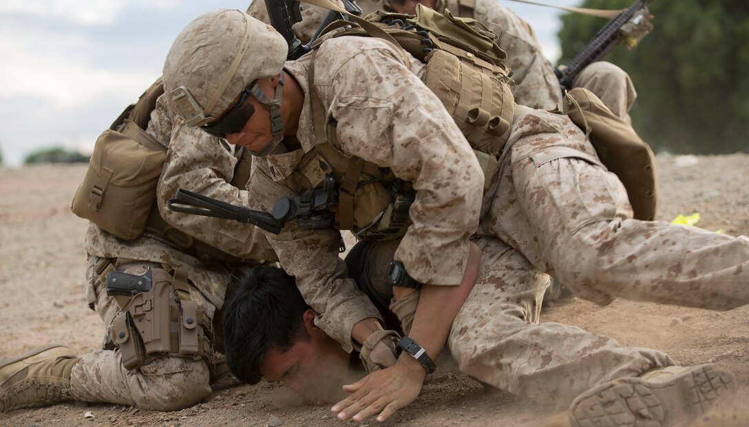 Marines with 2nd Battalion, 7th Marine Regiment, based out of Marine Corps Air Ground Combat Center Twentynine Palms, Calif., apprehend a role-player in a riot control mission scenario during a non-combatant evacuation exercise at Kiwanis Park in Yuma, Ariz., Friday, Oct. 16, 2015. The Marines were tasked and evaluated on their ability to maintain control of role-players simulating hostile behavior.