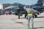 U.S. Air Force Tech. Sgt. Robbin Bruning, 140th Maintenance Squadron, Colorado Air National Guard, ushers in an F-16 Fighting Falcon during the wing’s readiness inspection at Buckley Air Force Base, Aurora, Colorado, Oct. 16, 2015. This training is a part of the 140th Wing’s four-day Wing Wartime Readiness Inspection, the U.S. Air Force’s new evaluation system for wartime, contingency and force sustainment readiness. 