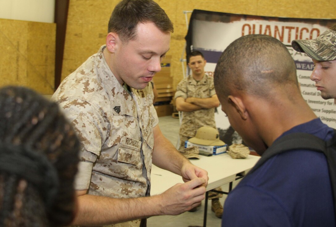 U.S. Marine Corps Sgt. Ronald L. Richards, a recruiter with Marine Corps Recruiting Sub- station Aberdeen, former marksmanship instructor, and Free Port, Illinois, native, shows a group of poolees the bolt from an AR-15 during a pool function at Quantico Tactical in Aberdeen, North Carolina, Oct. 10, 2015. The Marines taught the poolees proper weapons handling, aiming and marksmanship to give them a unique experience and teach them skill sets that will be useful at recruit training. (U.S. Marine Corps photo by Sgt. Dwight A. Henderson/Released)