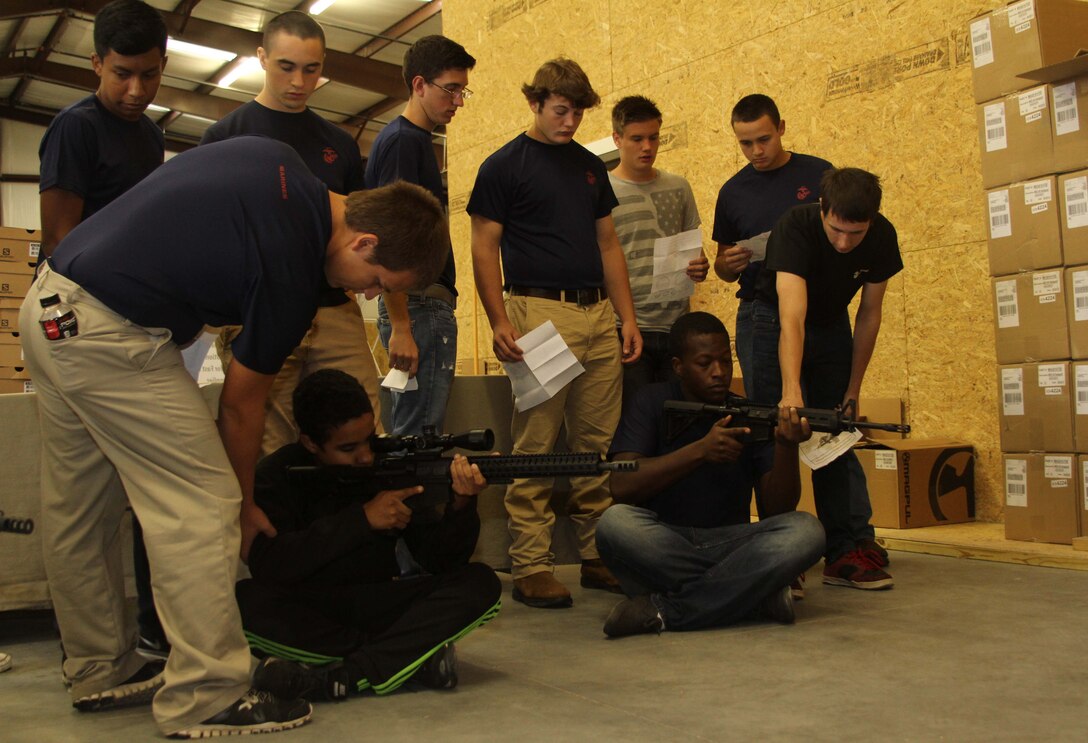 Poolees from Marine Corps Recruiting Sub-station Aberdeen, North Carolina, correct each other’s seated position during a pool function at Quantico Tactical in Aberdeen, North Carolina, Oct. 10, 2015. The Marines taught the poolees proper weapons handling, aiming and marksmanship to give them a unique experience and teach them skill sets that will be useful at recruit training. (U.S. Marine Corps photo by Sgt. Dwight A. Henderson/Released)