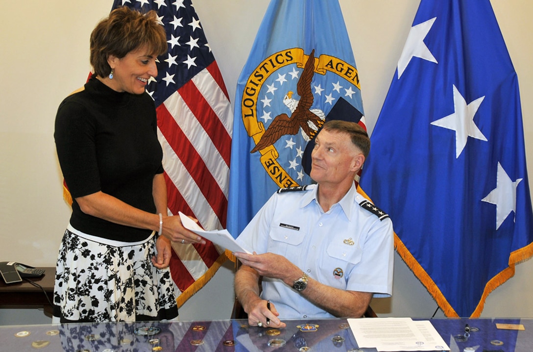 Defense Logistics Agency Director Air Force Lt. Gen. Andy Busch hands the agency’s signed assertion letters to Simone Reba, deputy director of DLA Finance Sept. 30. The letters, which state that the agency’s financial statements are ready for its first full audit, will now be sent to the Office of the Under Secretary of Defense (Comptroller) for review and approval.