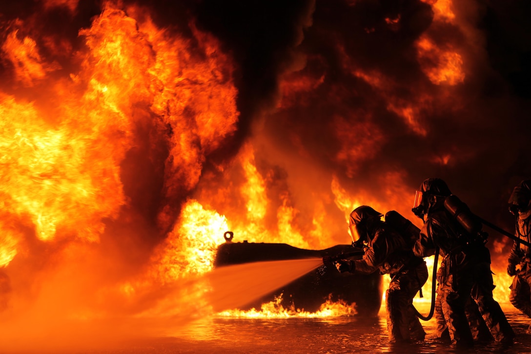 Battling the heat from the flames, Aircraft Rescue and Firefighting Marines extinguish some of their first fuel fires at Marine Corps Air Station Cherry Point, N.C., Oct. 16, 2015. The training exercise taught the new Marines to battle the heat and keep pushing until they annihilate the flames, as well as get used to the environment of a real fire. (U.S. Marine Corps photo by Pfc. Nicholas P. Baird/ Released)
