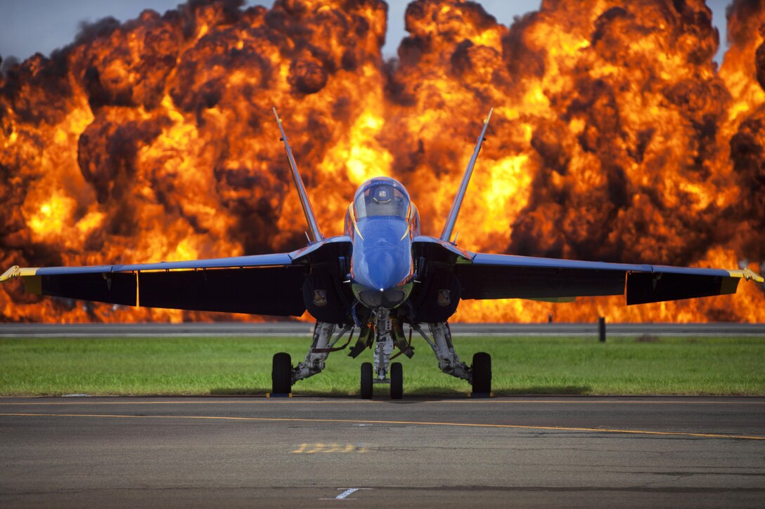 An F/A-18 Hornet belonging to the Blue Angels, the U.S. Navy's flight demonstration team, is illuminated by the "Wall of Fire" during the 2015 Kaneohe Bay Air Show at Marine Corps Base Hawaii, Oct. 16, 2015. U.S. Marine Corps photo by Lance Cpl. Julian Temblador