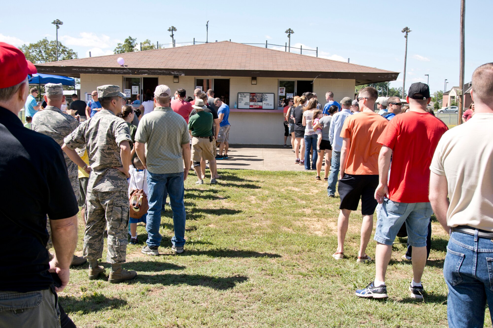 Hungry Airmen, co-workers and family members wait in line for lunch at the 913th Airlift Group’s “Family Day” celebration at Little Rock Air Force Base, Ark., Sept. 12, 2015. Approximately 1,000 people participated in the annual event, which promotes taking care of the unit’s family members. The event feature a wide array of events, including a working dog (K-9) demonstration, face painting, softball, bean bag toss and a sack hop race. (Courtesy photo by Eva Walston/Released)  
