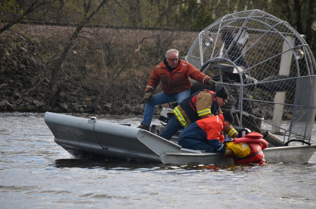 WINONA, Minn., -- From left, Kurt Ressie, U.S. Army Corps of Engineers, St. Paul District, small craft operator Winona, Minn., Fire Department Capt. Duane Chadbourn; and Dan Cottrell, U.S. Army Corps of Engineers, St. Paul District, channel maintenance coordinator; pull Winona Fire Department Capt. Jason Theusch from the water during a joint cold water rescue training event March 28 on the Mississippi River. This was the first time that both agencies trained together and they both plan on making it an annual event.