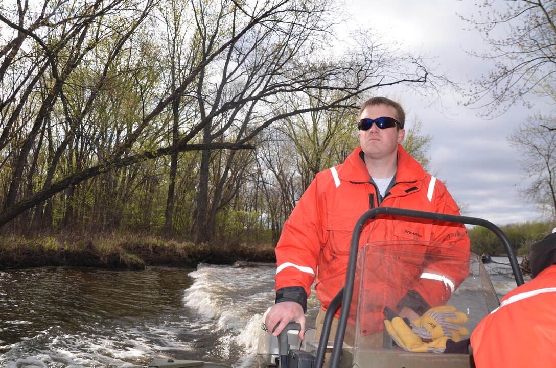 Brandon Olson, operations, watches the cold water rescue training as he operates a small boat. 