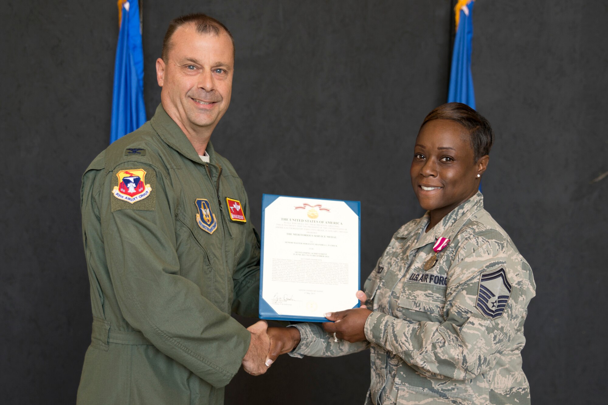 U.S. Air Force Col. Craig Drescher, commander, 913th Airlift Group, and Senior Master Sgt. Shandra Patrick, superintendent, 913th Aerospace Medical Squadron, pose for a photo during Commander’s Call at Little Rock Air Force Base, Ark., Sept. 13, 2015. Patrick was awarded the Meritorious Service Medal for outstanding achievement as the Noncommissioned Officer In Charge of Medical Readiness and Inspection Services from 15 June 2011 to 31 December 2014. Colonel Drescher also recognized 23 additional Airmen for personal achievements. (U.S. Air Force photo by Master Sgt. Jeff Walston/Released) 