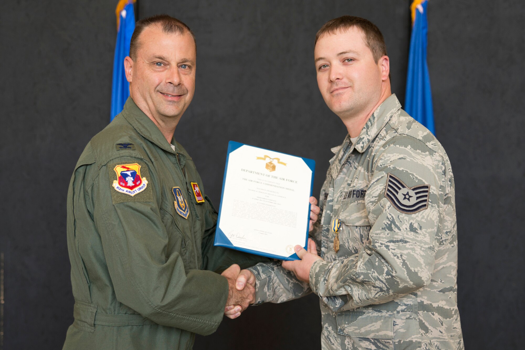 U.S. Air Force Col. Craig Drescher, commander, 913th Airlift Group, and Tech Sgt. Dillon Lawrence, 96th Aerial Port Squadron, pose for a photo during Commander’s Call at Little Rock Air Force Base, Ark., Sept. 13, 2015. Lawrence was awarded the Air Force Commendation Medal for meritorious service from 19 April 2011 to 24 February 2014. Colonel Drescher also recognized 23 additional Airmen for personal achievements. (U.S. Air Force photo by Master Sgt. Jeff Walston/Released) 
