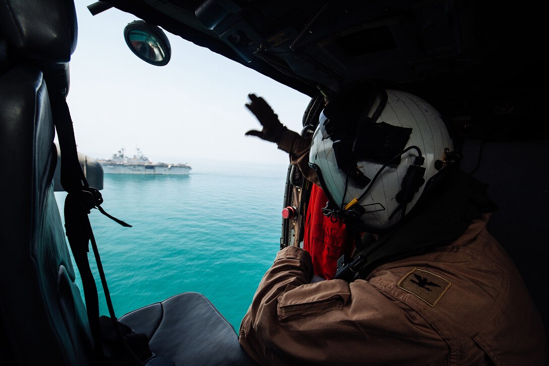 U.S. Navy Capt. Pete M. Mantz waves to the USS Essex for his final time after conducting an aerial lead change ceremony with Capt. Brian J. Quin, the Essex's executive officer, in the Arabian Gulf, Oct. 17, 2015. The Essex is supporting security efforts in the U.S. 5th Fleet area of responsibility. U.S. Navy photo by Petty Officer 2nd Class Liam Kennedy