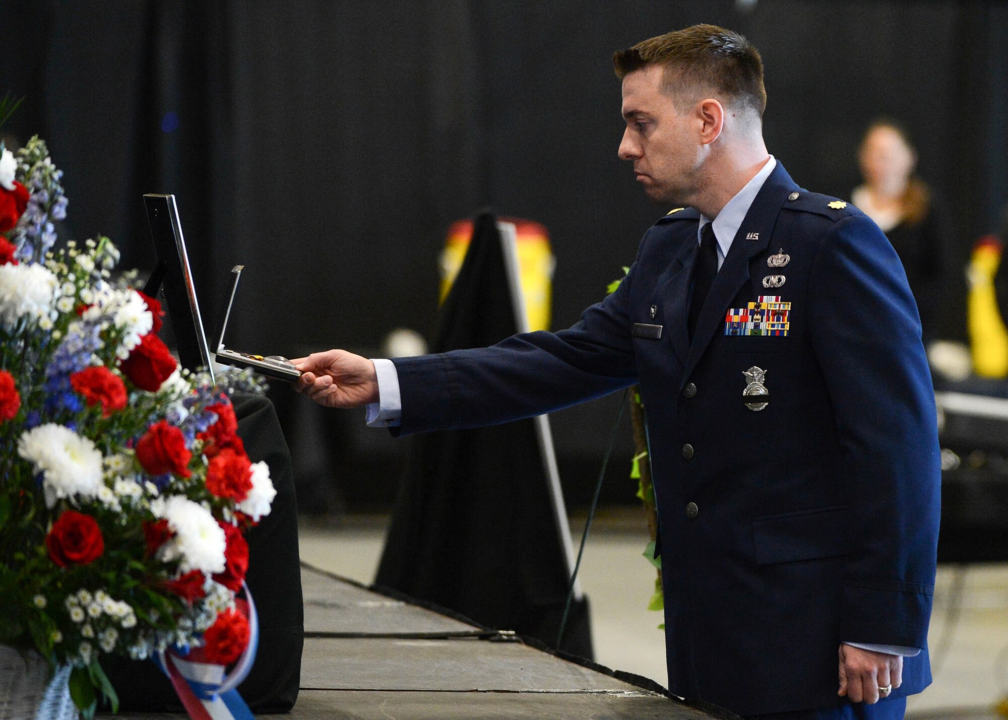 Maj. Joseph Bincarousky, 66th Security Forces Squadron commander, posthumously presents Senior Airman Nathan Sartain and Senior Airman Kcey Ruiz the Air Force Commendation Medal during a memorial service at the Aero Club Hangar Oct. 16. The service was held to honor and remember the two Airmen killed Oct. 2 when the C-130J Super Hercules aircraft they were on crashed shortly after take-off from Jalalabad, Afghanistan. (U.S. Air Force photo/Jerry Saslav)