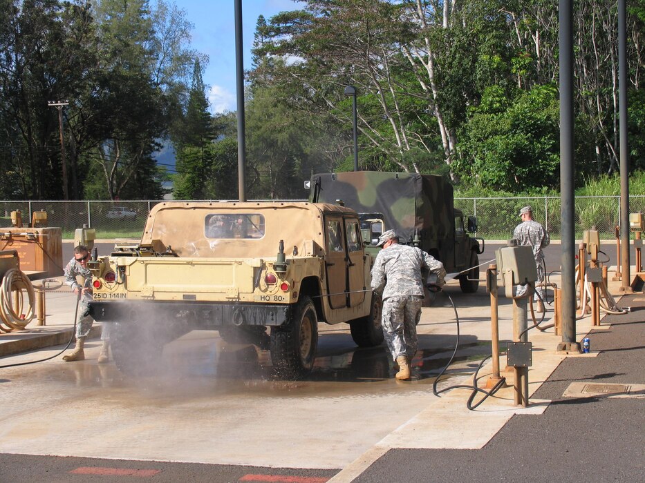 Soldiers using the Schofield Barracks Centralized Wash Facility to remove dirt and potential plant propagules from Humvee. Using a high pressure low volume wand ensures minimal water utilization and maximum debris removal. Effluent for this facility is recycled through a grit chamber, oil chamber, and through a series of sand and membrane.
