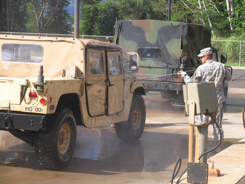 Soldiers using the Schofield Barracks Centralized Wash Facility to remove dirt and potential plant propagules from Humvee. Using a high pressure low volume wand ensures minimal water utilization and maximum debris removal. Effluent for this facility is recycled through a grit chamber, oil chamber, and through a series of sand and membrane.