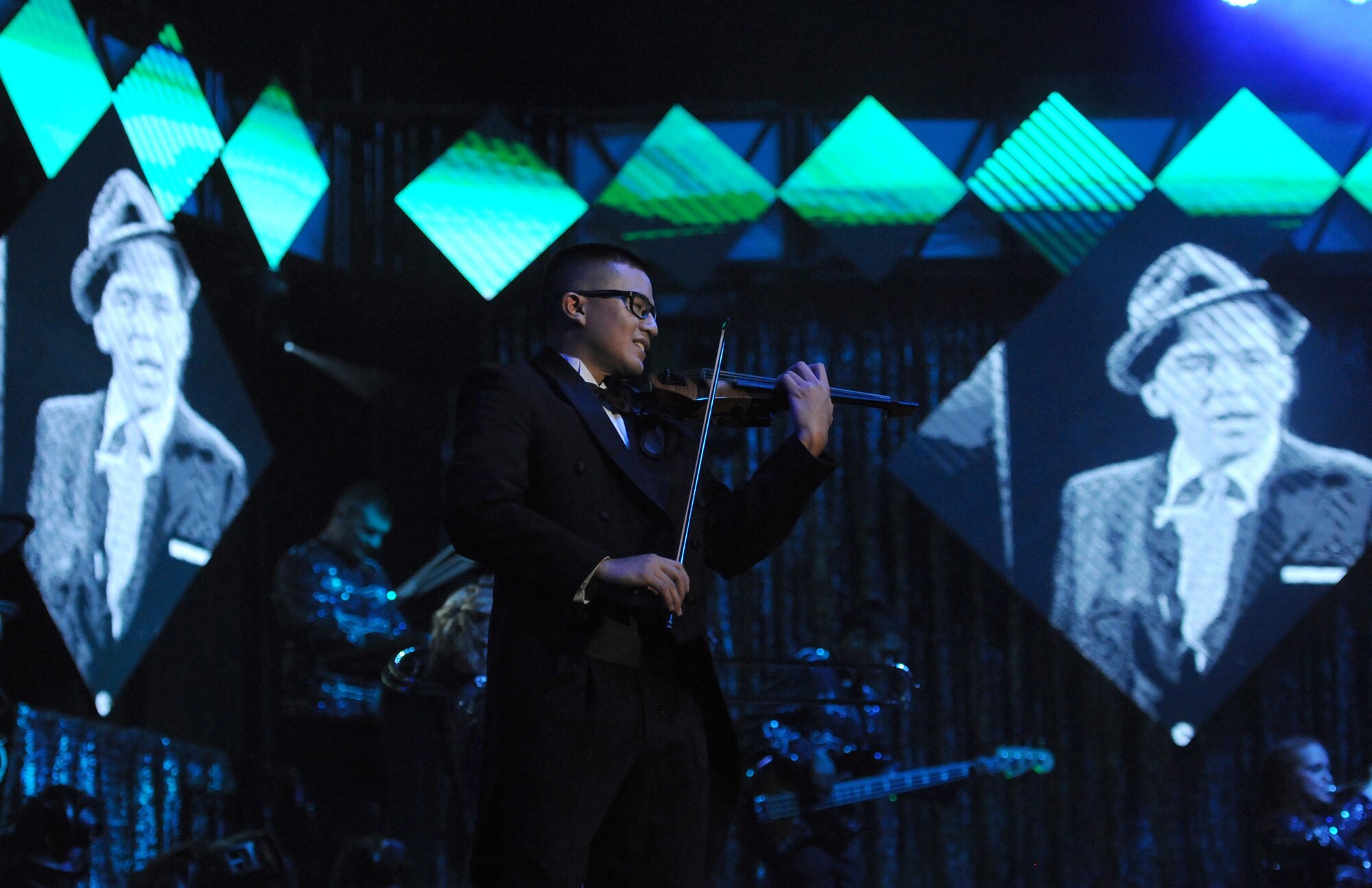 First Lt. Oliver Chang plays the violin during a performance by Tops in Blue during their 2015 World Tour at the Mississippi Coast Coliseum, Oct. 17, 2015, Biloxi, Miss. Hundreds of Keesler Airmen, families and community members watched and listened as the sequin-studded members of Tops in Blue performed their diverse show. This year’s tour takes the group to 20 countries with more than 75 performances. For more information on the team or audition requirements, visit www.topsinblue.com.  (U.S. Air Force photo by Kemberly Groue)