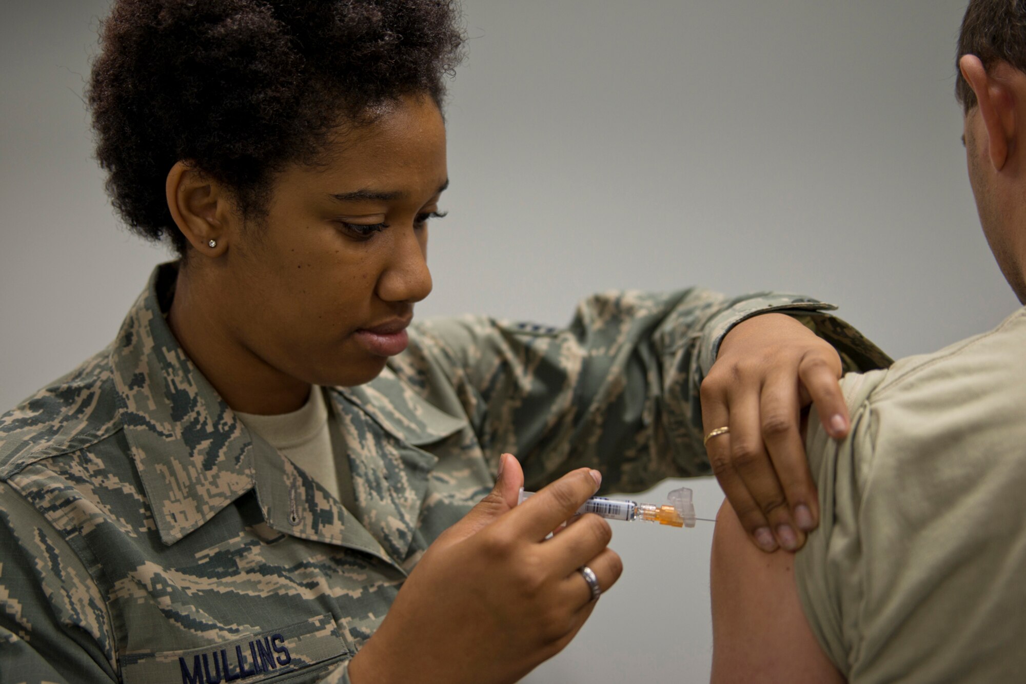U.S. Air Force Senior Airman Kyla Mullins, a medical technician assigned to the 913th Aerospace Medical Squadron, inoculates an Airman with the Influenza Vaccine during the October Unit Training Assembly at Little Rock Air Force Base, Ark., Oct. 3, 0215. Annual inoculations of military personnel can help protect them as well as their family, friends and co-workers from catching the flu. (U.S. Air Force photo by Master Sgt. Jeff Walston/Released)